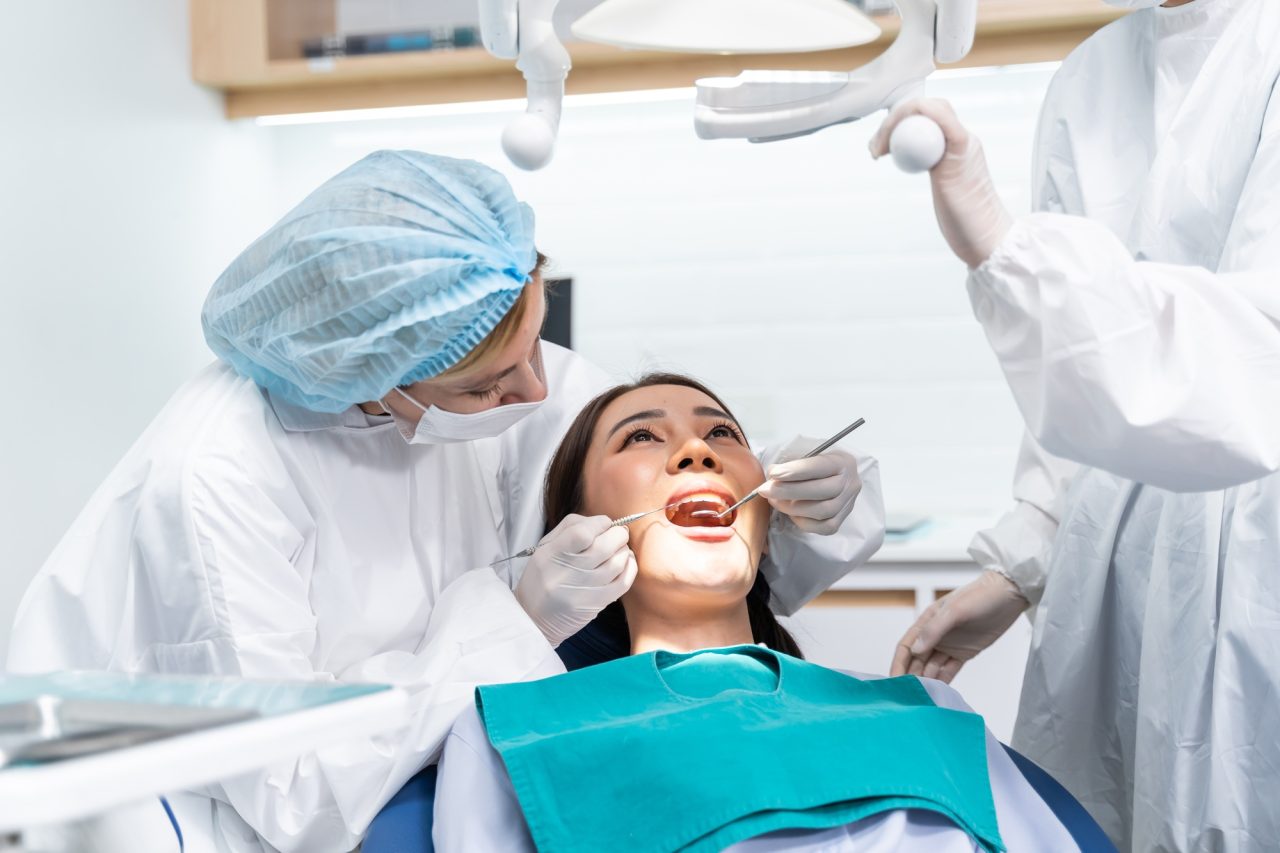 Caucasian dentist examine tooth for young girl at dental health clinic .jpg