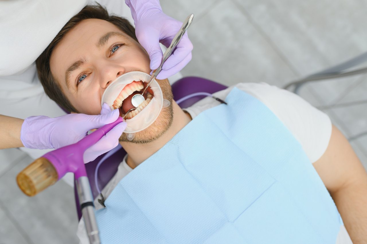 Periodontal services closeup shot of smiling man getting treatment in stomatologic clinic.jpg