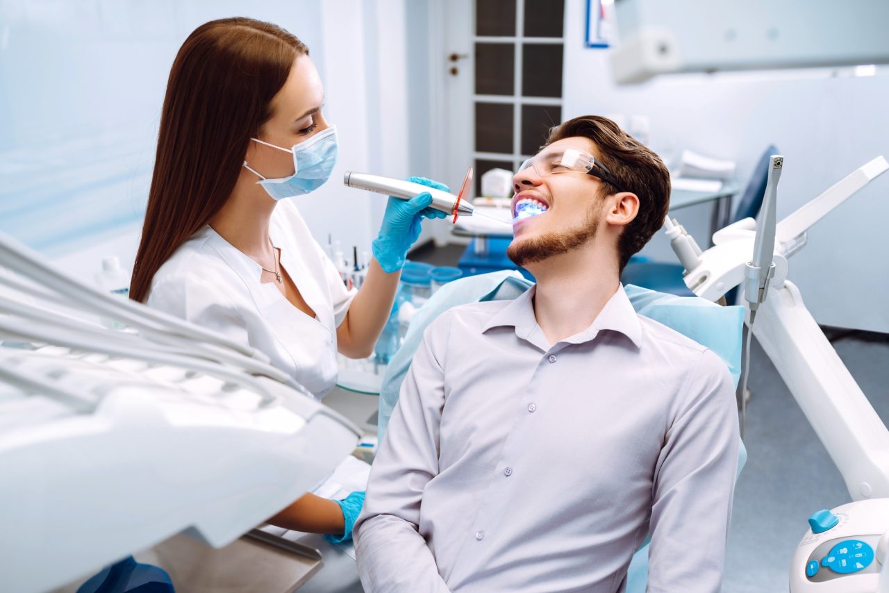 Young man at the dentist s chair during a dental procedure overview of dental caries prevention .jpg